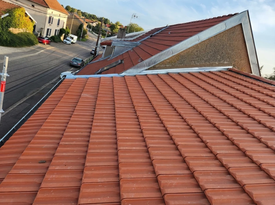 Vue aérienne d'une toiture en tuiles canal terre cuite rouge-brun, en excellent état, depuis un échafaudage