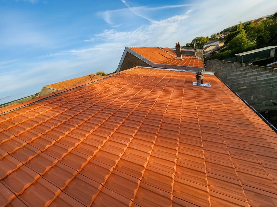 Toiture neuve vue en plongée, tuiles canal en terre cuite rouge-orangé disposées en rangées régulières